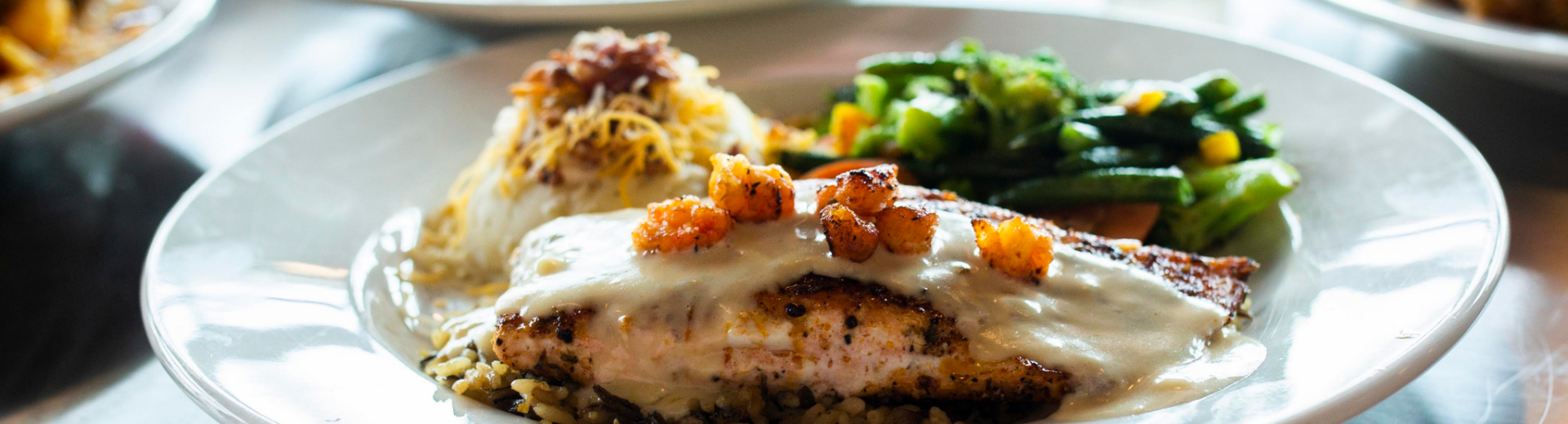 A plate of fish, rice, mashed potatoes and green beans, prepared by House Divided